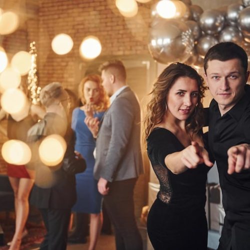 pareja-joven-pie-junto-sus-amigos-habitacion-decorada-navidad-celebrando-ano-nuevo-146671-32004-jpg